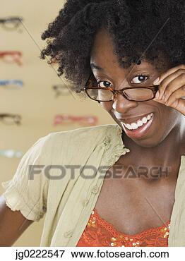 Picture - young woman trying 
on new glasses. 
fotosearch - search 
stock photos, 
pictures, images, 
and photo clipart