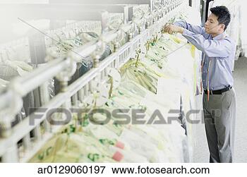 Picture - asian drycleaner 
checking clothes, 
edmonds, washington, 
united states. 
fotosearch - search 
stock photos, 
pictures, images, 
and photo clipart