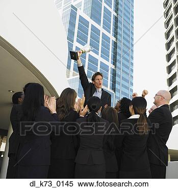 Stock Image - businessman and 
co-workers cheering 
with trophy, perth, 
australia. fotosearch 
- search stock 
photos, pictures, 
images, and photo 
clipart