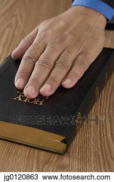Stock Photo - close up of male 
hand on bible. 
fotosearch - search 
stock photos, 
pictures, images, 
and photo clipart