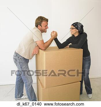 Stock Photography - couple arm wrestling 
on boxes in new 
house. fotosearch 
- search stock 
photos, pictures, 
images, and photo 
clipart
