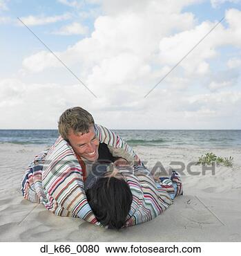 Stock Photography - couple wrapped 
in a blanket on 
the beach, busselton, 
australia. fotosearch 
- search stock 
photos, pictures, 
images, and photo 
clipart
