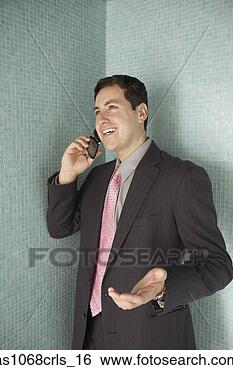 Stock Photo - hispanic businessman 
standing in a 
corner talking 
on his cell phone. 
fotosearch - search 
stock photos, 
pictures, images, 
and photo clipart