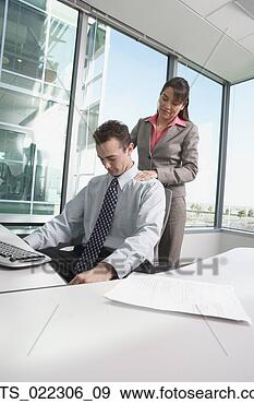 Stock Photograph - hispanic businesswoman 
giving hispanic 
businessman a 
shoulder massage. 
fotosearch - search 
stock photos, 
pictures, images, 
and photo clipart