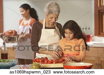 Stock Photo - hispanic grandmother 
and granddaughter 
cutting tomatoes 
in the. fotosearch 
- search stock 
photos, pictures, 
images, and photo 
clipart