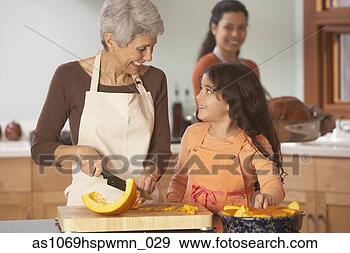 Stock Photograph - hispanic grandmother 
and granddaughter 
cutting pumpkin 
in the. fotosearch 
- search stock 
photos, pictures, 
images, and photo 
clipart
