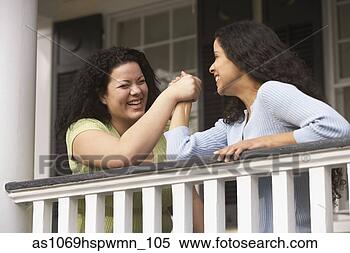 Stock Image - hispanic sisters 
arm wrestling 
on a porch railing, 
 richmond. fotosearch 
- search stock 
photos, pictures, 
images, and photo 
clipart