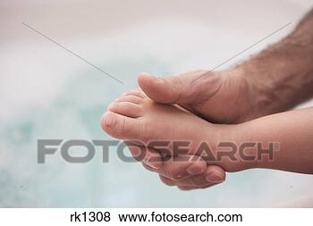 Stock Photo - man holding young 
child's foot. 
fotosearch - search 
stock photos, 
pictures, images, 
and photo clipart