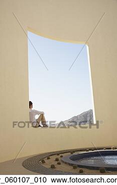 Stock Photography - man sitting in 
large open air 
window next to 
pool, los cabos, 
mexico. fotosearch 
- search stock 
photos, pictures, 
images, and photo 
clipart