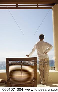 Stock Photo - man standing on 
balcony of resort 
hotel, los cabos, 
mexico. fotosearch 
- search stock 
photos, pictures, 
images, and photo 
clipart