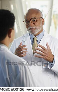 Stock Photo - middle-aged african 
doctor talking 
to co-worker. 
fotosearch - search 
stock photos, 
pictures, images, 
and photo clipart