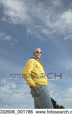 Stock Photo - middle-aged man 
standing under 
a blue sky with 
his hand in his 
back. fotosearch 
- search stock 
photos, pictures, 
images, and photo 
clipart