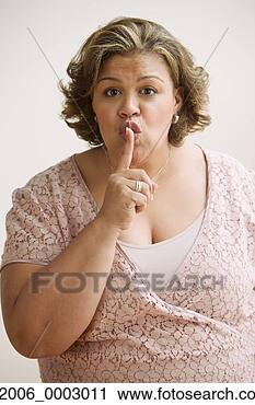 Stock Photography - middle-aged overweight 
hispanic woman 
with her index 
finger up to her. 
fotosearch - search 
stock photos, 
pictures, images, 
and photo clipart