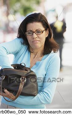 Stock Photography - middle-aged woman 
digging in her 
purse, miami, 
florida, united 
states. fotosearch 
- search stock 
photos, pictures, 
images, and photo 
clipart