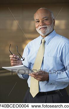 Stock Photo - senior african 
businessman holding 
eyeglasses. fotosearch 
- search stock 
photos, pictures, 
images, and photo 
clipart