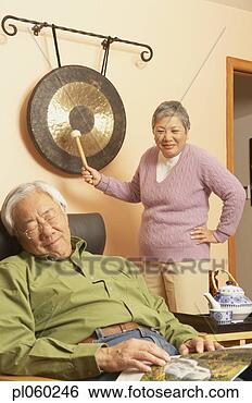 Stock Photo - senior asian woman 
waking up senior 
asian man with 
gong,  san rafael. 
fotosearch - search 
stock photos, 
pictures, images, 
and photo clipart