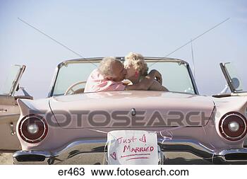 Stock Photo - senior couple 
kissing in pink 
convertible with 
just married sign. 
fotosearch - search 
stock photos, 
pictures, images, 
and photo clipart