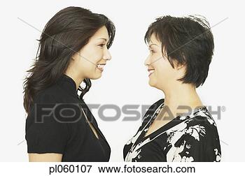 Picture - studio shot of 
asian mother and 
adult daughter 
face to face smiling. 
fotosearch - search 
stock photos, 
pictures, images, 
and photo clipart