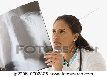 Stock Image - studio shot of 
a female colombian 
doctor looking 
at an x-ray. fotosearch 
- search stock 
photos, pictures, 
images, and photo 
clipart