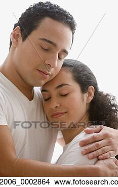 Stock Photo - studio shot of 
hispanic couple 
hugging with their 
eyes closed. fotosearch 
- search stock 
photos, pictures, 
images, and photo 
clipart
