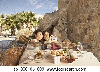 Stock Photograph - two women taking 
a photograph of 
themselves at 
a resort hotel, 
 los. fotosearch 
- search stock 
photos, pictures, 
images, and photo 
clipart