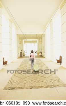 Stock Photo - woman walking 
out of hotel lobby 
with suitcase, 
los cabos, mexico. 
fotosearch - search 
stock photos, 
pictures, images, 
and photo clipart