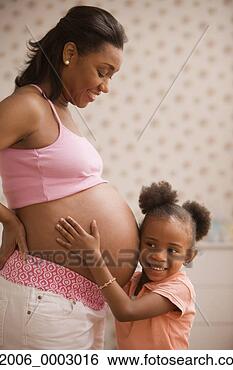 Stock Photo - young african 
daughter listening 
to her pregnant 
mother's bare 
belly. fotosearch 
- search stock 
photos, pictures, 
images, and photo 
clipart