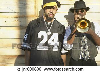 Stock Photography - young african 
man standing next 
to senior african 
man playing. fotosearch 
- search stock 
photos, pictures, 
images, and photo 
clipart