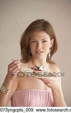 Stock Photograph - young woman eating 
a small dessert, 
richmond, virginia, 
united states. 
fotosearch - search 
stock photos, 
pictures, images, 
and photo clipart