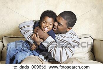 Stock Image - african american 
father and young 
son playing on 
sofa. fotosearch 
- search stock 
photos, pictures, 
images, and photo 
clipart