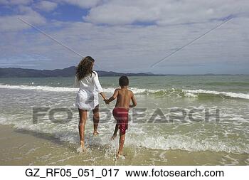 Picture - african mother 
and son running 
in the surf, florianopolis, 
brazil. fotosearch 
- search stock 
photos, pictures, 
images, and photo 
clipart