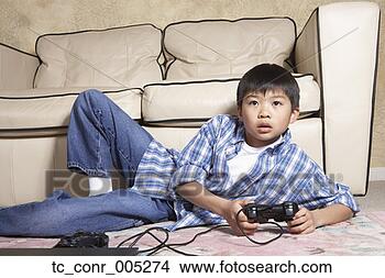 Stock Photo - asian boy playing 
video games. fotosearch 
- search stock 
photos, pictures, 
images, and photo 
clipart