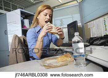 Stock Photo - businesswoman 
eating lunch at 
desk. fotosearch 
- search stock 
photos, pictures, 
images, and photo 
clipart