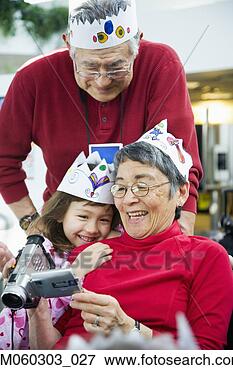 Picture - grandparents and 
granddaughter 
looking at videocamera. 
fotosearch - search 
stock photos, 
pictures, images, 
and photo clipart