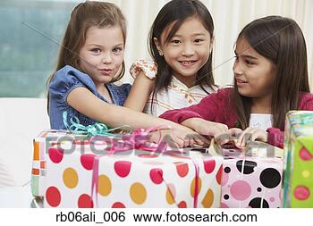 Stock Photo - group of young 
girls opening 
gifts. fotosearch 
- search stock 
photos, pictures, 
images, and photo 
clipart