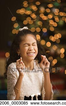 Stock Image - hispanic girl 
with fingers crossed 
and eyes closed 
in front of. fotosearch 
- search stock 
photos, pictures, 
images, and photo 
clipart