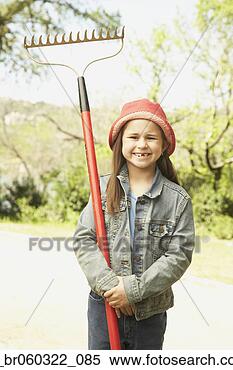 Stock Image - hispanic girl 
holding rake outdoors. 
fotosearch - search 
stock photos, 
pictures, images, 
and photo clipart