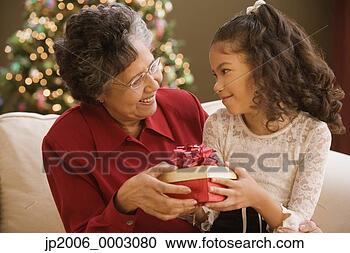 Stock Photography - hispanic grandmother 
and granddaughter 
holding christmas 
gift. fotosearch 
- search stock 
photos, pictures, 
images, and photo 
clipart