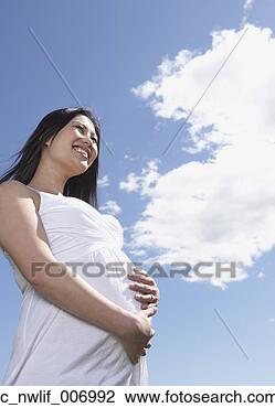 Stock Photo - low angle view 
of pregnant asian 
woman under blue 
sky. fotosearch 
- search stock 
photos, pictures, 
images, and photo 
clipart