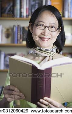 Stock Photograph - middle-aged asian 
woman reading 
book. fotosearch 
- search stock 
photos, pictures, 
images, and photo 
clipart