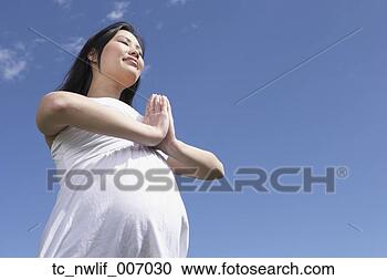 Stock Photography - pregnant asian 
woman doing yoga 
outdoors. fotosearch 
- search stock 
photos, pictures, 
images, and photo 
clipart