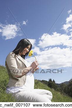 Picture - pregnant asian 
woman holding 
flower outdoors. 
fotosearch - search 
stock photos, 
pictures, images, 
and photo clipart