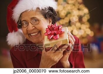 Stock Photography - senior hispanic 
woman holding 
christmas gift. 
fotosearch - search 
stock photos, 
pictures, images, 
and photo clipart