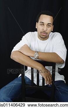Stock Photograph - studio shot of 
african american 
man sitting in 
chair. fotosearch 
- search stock 
photos, pictures, 
images, and photo 
clipart