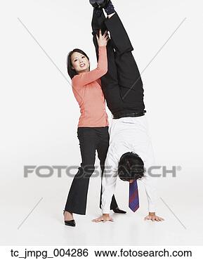 Stock Photo - studio shot of 
asian businessman 
doing handstand 
with asian. fotosearch 
- search stock 
photos, pictures, 
images, and photo 
clipart