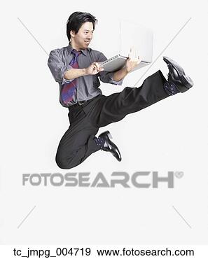 Stock Photograph - studio shot of 
asian businessman 
jumping in air 
with laptop. fotosearch 
- search stock 
photos, pictures, 
images, and photo 
clipart