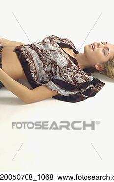 Stock Photo - studio shot of 
woman lying on 
floor with eyes 
closed. fotosearch 
- search stock 
photos, pictures, 
images, and photo 
clipart