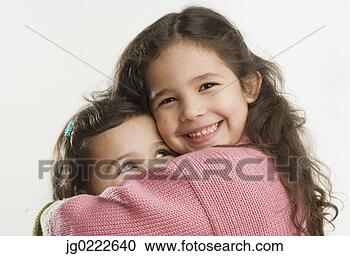 Stock Photography - studio shot of 
young hispanic 
sisters hugging. 
fotosearch - search 
stock photos, 
pictures, images, 
and photo clipart