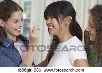 Stock Image - teenaged girls 
applying lipstick. 
fotosearch - search 
stock photos, 
pictures, images, 
and photo clipart