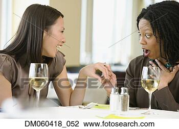 Stock Photo - woman showing 
friend engagement 
ring at restaurant. 
fotosearch - search 
stock photos, 
pictures, images, 
and photo clipart